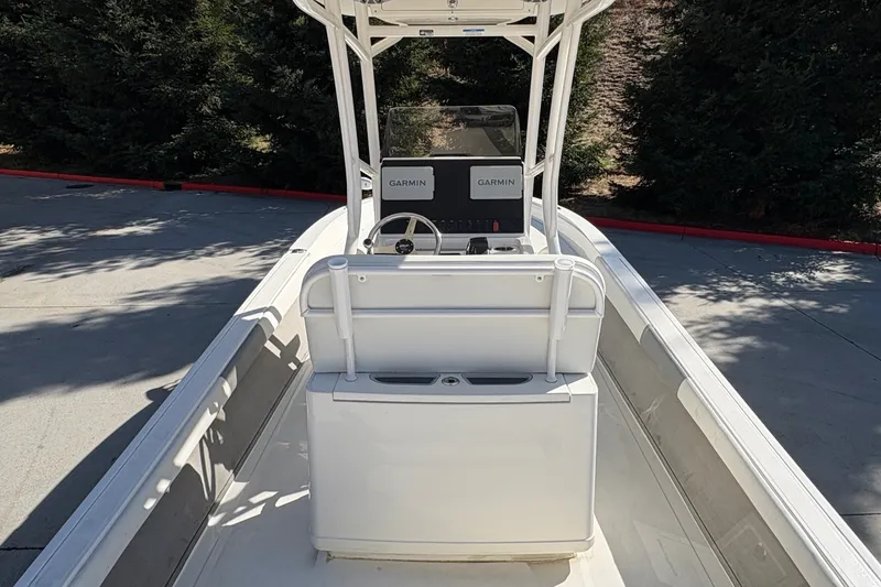 Slide: The Image of 2026 Mako 24 APEX boat interior with Garmin navigation system, parked outdoors. - 21