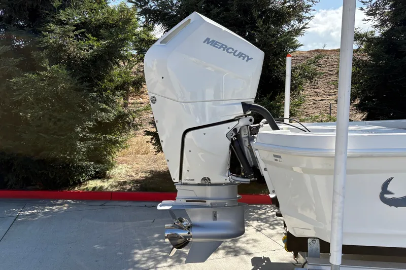Slide: The Image of Outboard motor on a 2026 Mako 24 APEX boat, parked outdoors. - 9