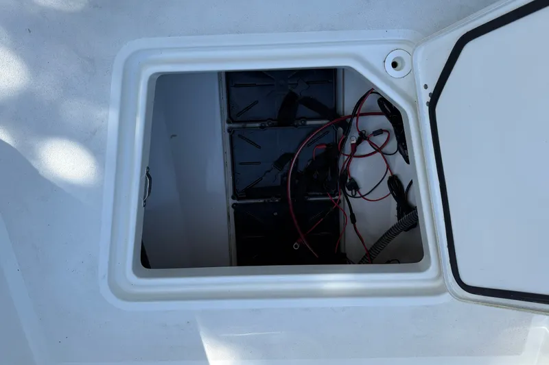 Slide: The Image of Open hatch of 2026 Mako 24 APEX boat showing internal wiring and components. - 26