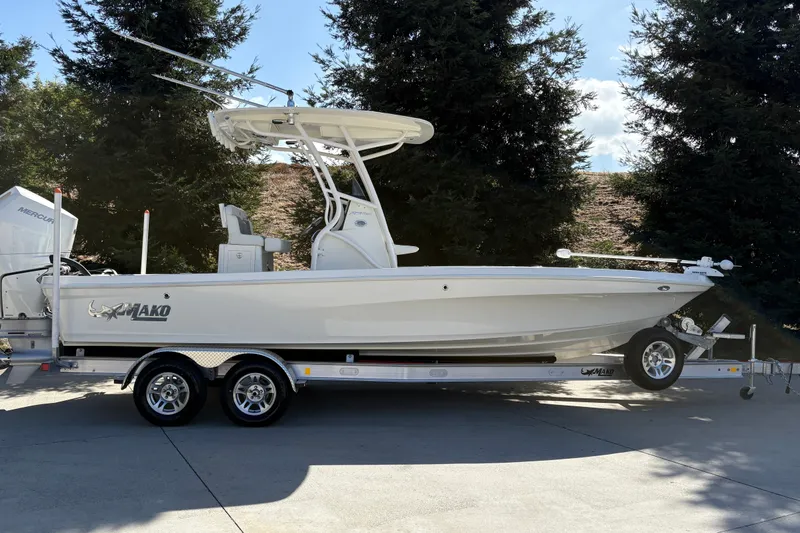 The Image of 2026 Mako 24 APEX boat on trailer, parked outdoors with trees in background. - 0