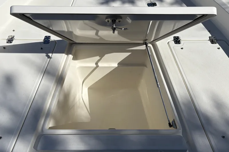 Slide: The Image of Open storage compartment on 2026 Mako 24 APEX boat, showcasing spacious interior. - 29
