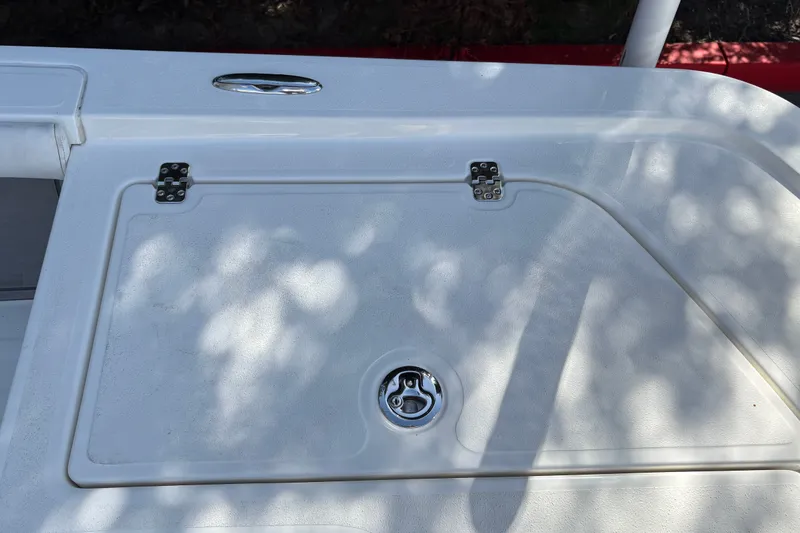 Slide: The Image of Hatch cover on 2026 Mako 24 APEX boat, featuring stainless steel hinges and latch. - 36