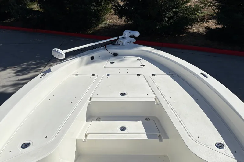 Slide: The Image of Bow view of 2026 Mako 24 APEX boat with trolling motor and storage compartments. - 14