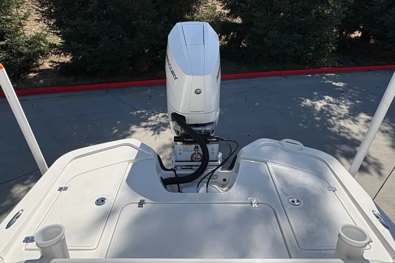 Slide: The Image of 2026 Mako 24 APEX boat with Mercury outboard motor, viewed from the stern. - 25