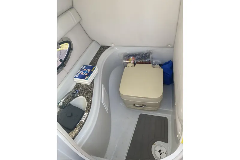 Slide: The Image of 2017 Crownline Eclipse E2 XS boat interior with sink, portable toilet, and first aid kit. - 4
