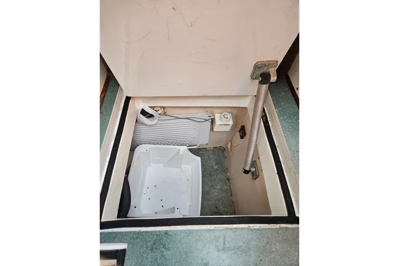 Slide: The Image of Interior storage compartment of a 1982 Kadey-Krogen 38 boat, featuring a white container. - 12