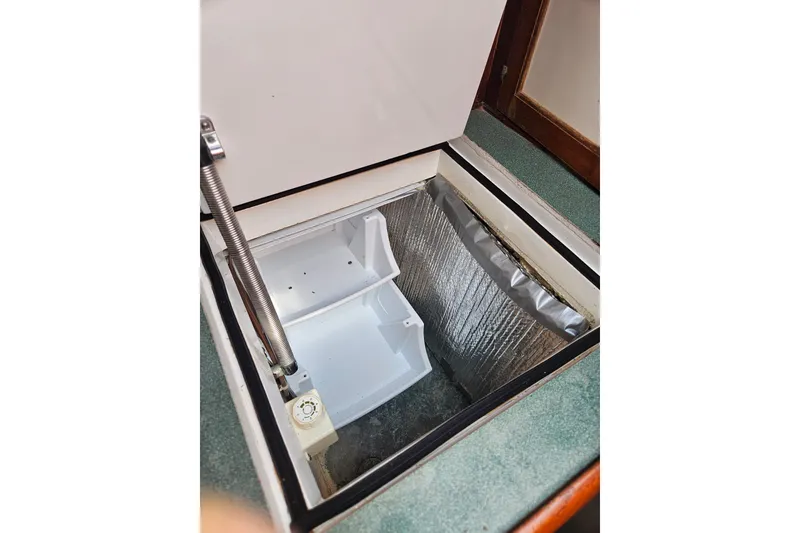 Slide: The Image of Open storage compartment on 1982 Kadey-Krogen 38 boat, featuring insulated interior. - 11