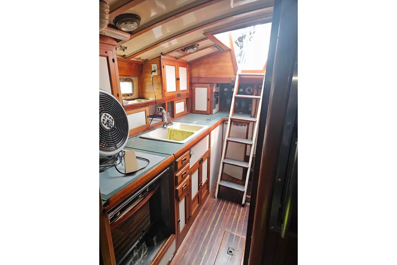 Slide: The Image of Interior of 1982 Kadey-Krogen 38 yacht featuring a compact kitchen with wooden cabinetry. - 10