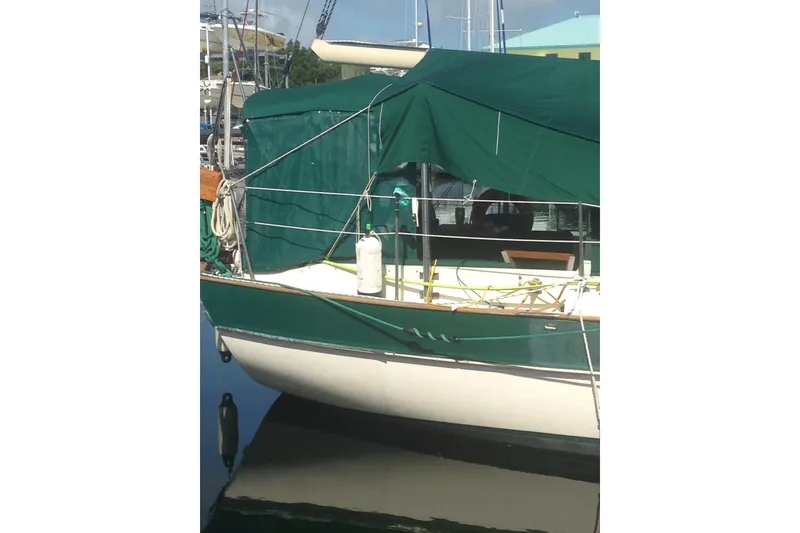 Slide: The Image of 1982 Kadey-Krogen 38 Dual Centerboard sailboat docked, covered with green canvas. - 13