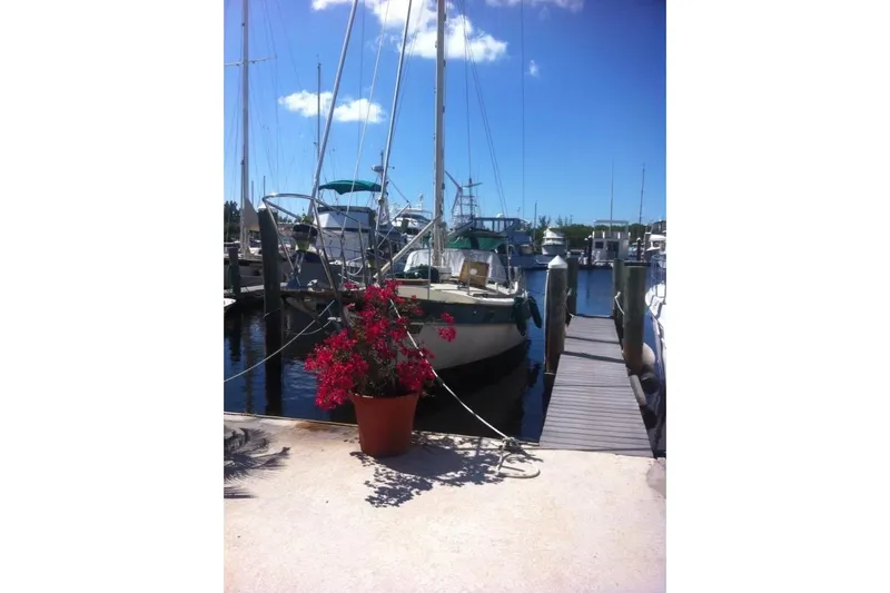 Slide: The Image of Kadey-Krogen 38 Dual Centerboard yacht docked at marina, 1982 model, with vibrant flowers nearby. - 16