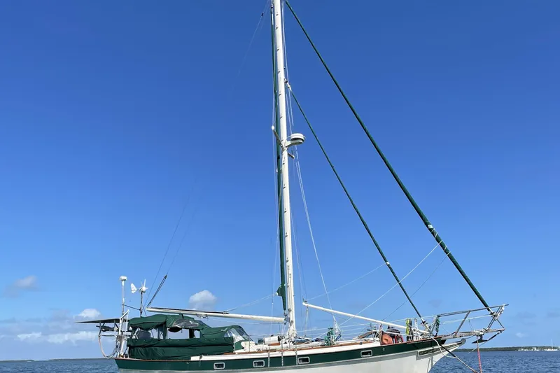Slide: The Image of 1982 Kadey-Krogen 38 Dual Centerboard sailboat on calm waters under clear blue sky. - 2