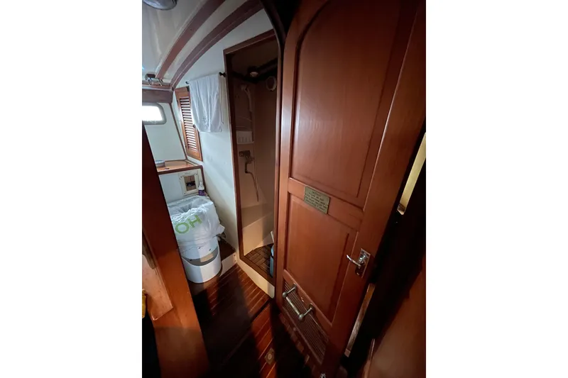 Slide: The Image of Interior of 1982 Kadey-Krogen 38 Dual Centerboard yacht, featuring wooden door and compact bathroom. - 21