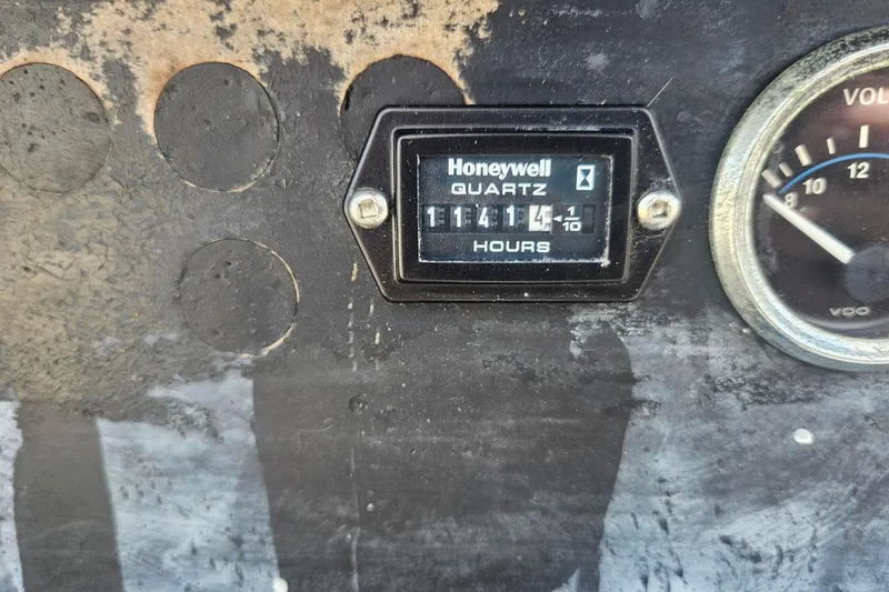 Slide: The Image of Hour meter and voltmeter on 1982 Kadey-Krogen 38 Dual Centerboard boat dashboard. - 23