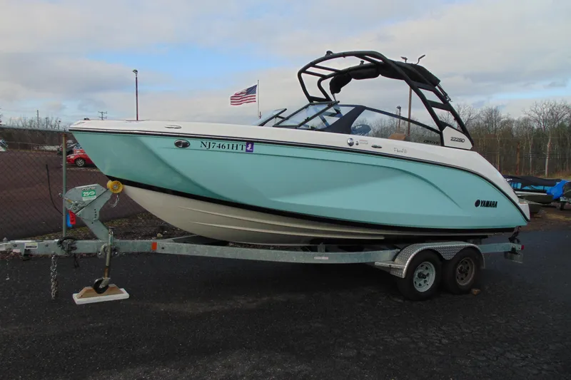 The Image of 2024 Yamaha Boats 222SD on trailer, light blue hull, parked outdoors. - 1