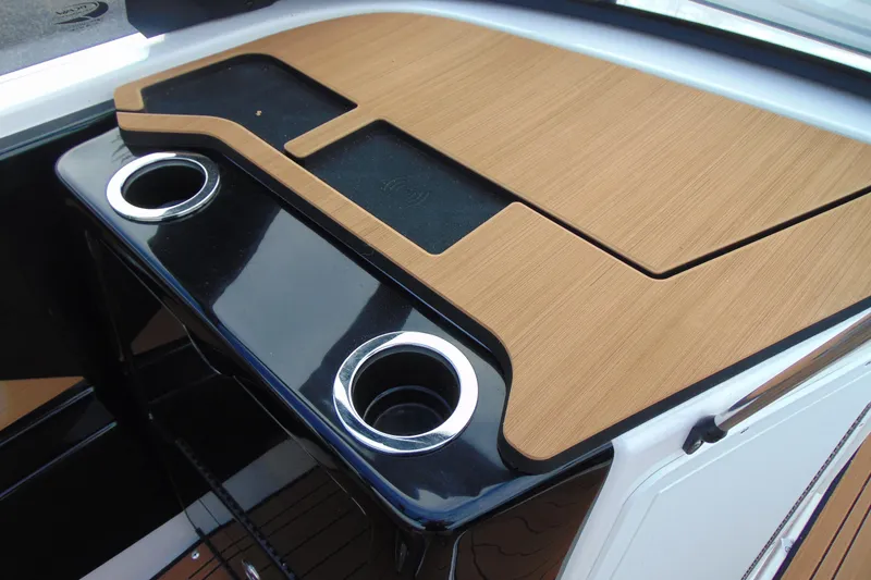 Slide: The Image of 2024 Yamaha Boats 222SD dashboard with wood finish and dual cup holders. - 10