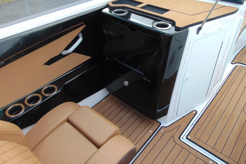Slide: The Image of 2024 Yamaha Boats 222SD interior with sleek black cabinetry and tan seating. - 8