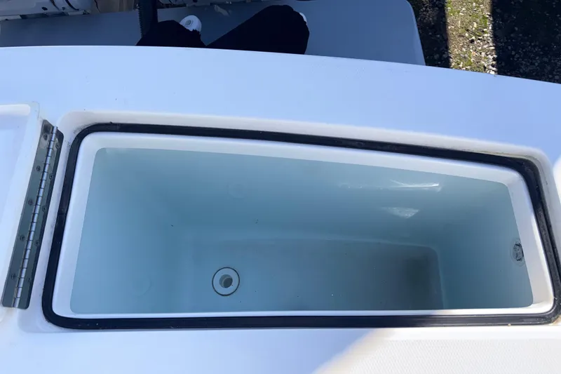 Slide: The Image of Livewell compartment on a 2023 Regulator 28 boat, featuring a clean, white interior. - 12