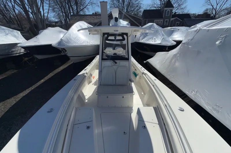 Slide: The Image of 2023 Regulator 28 boat, center console view, surrounded by covered boats in storage. - 16