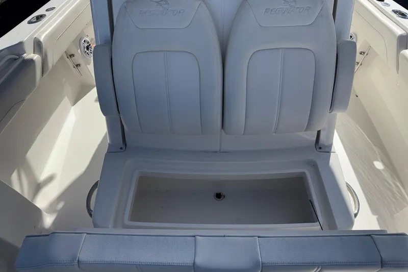 Slide: The Image of 2023 Regulator 28 boat interior with cushioned seating and storage compartment. - 17