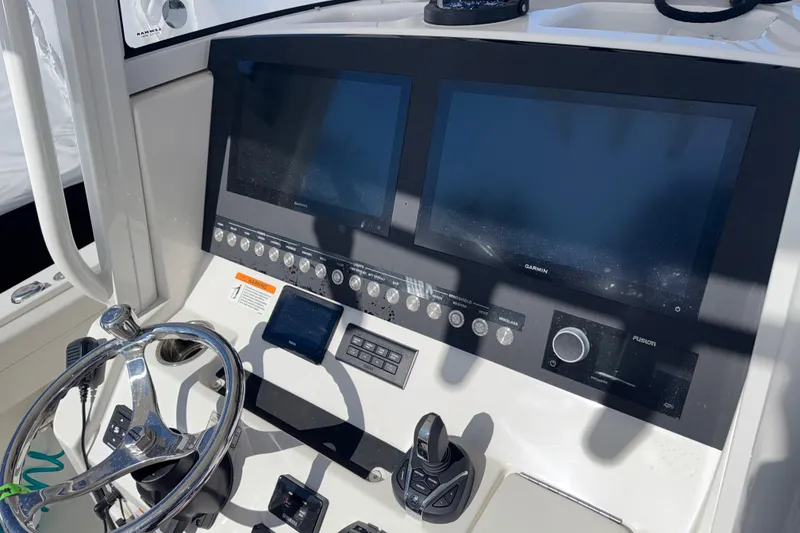 Slide: The Image of 2023 Regulator 28 boat dashboard with dual Garmin displays and steering wheel. - 5