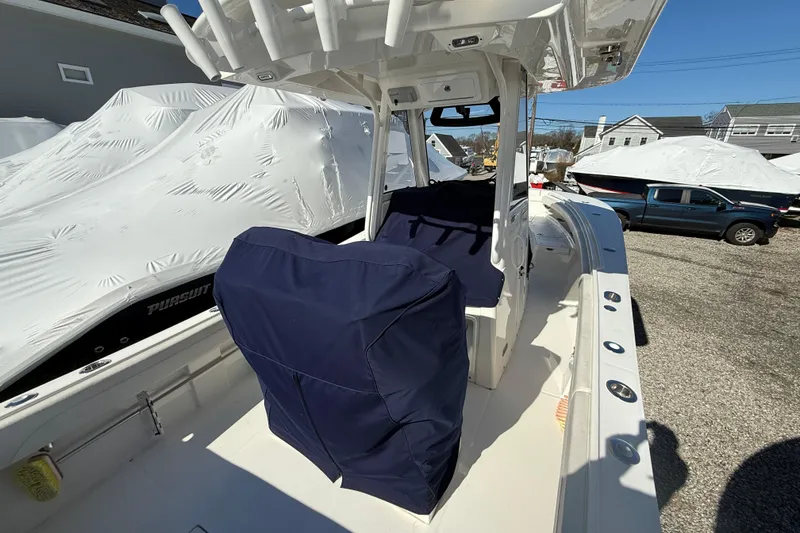 Slide: The Image of 2023 Regulator 28 boat interior with covered seats, parked outdoors. - 8