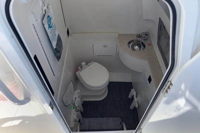 Slide: The Image of 2023 Regulator 28 boat interior bathroom with toilet and sink. - 9