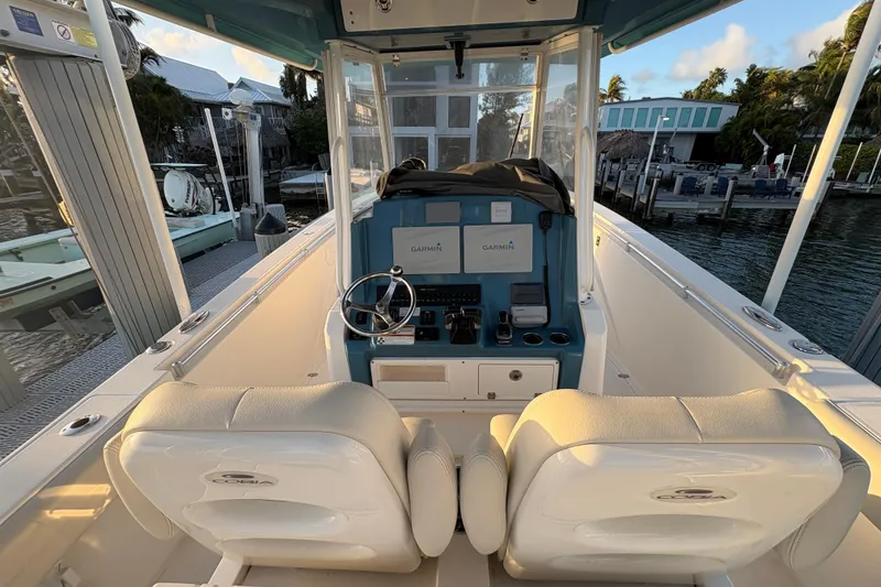 Slide: The Image of 2019 Cobia 320 Center Console boat interior with dual seats and Garmin navigation system. - 11