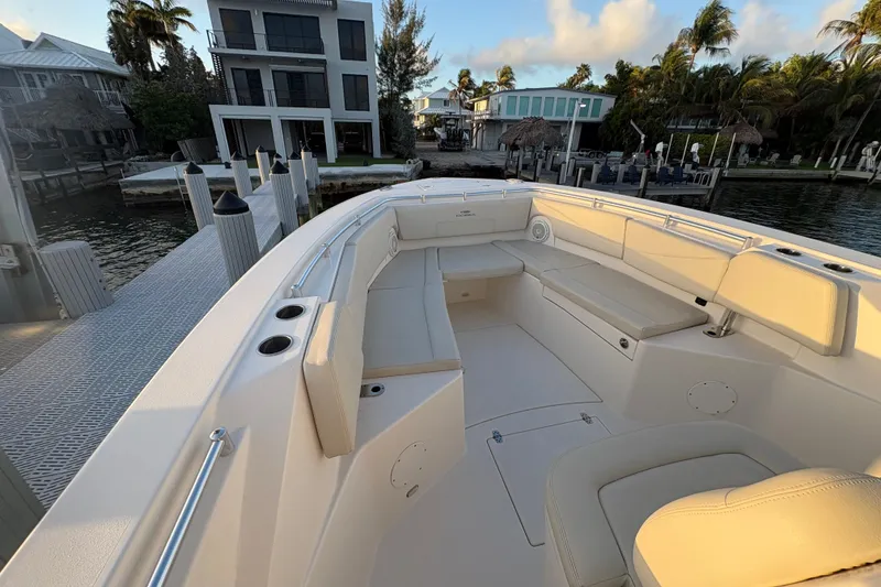 Slide: The Image of 2019 Cobia 320 Center Console boat docked near waterfront homes. - 15