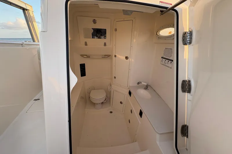 Slide: The Image of 2019 Cobia 320 Center Console boat interior with toilet and sink. - 16