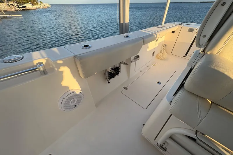 Slide: The Image of 2019 Cobia 320 Center Console boat interior with seating, ocean view, and sunset lighting. - 22