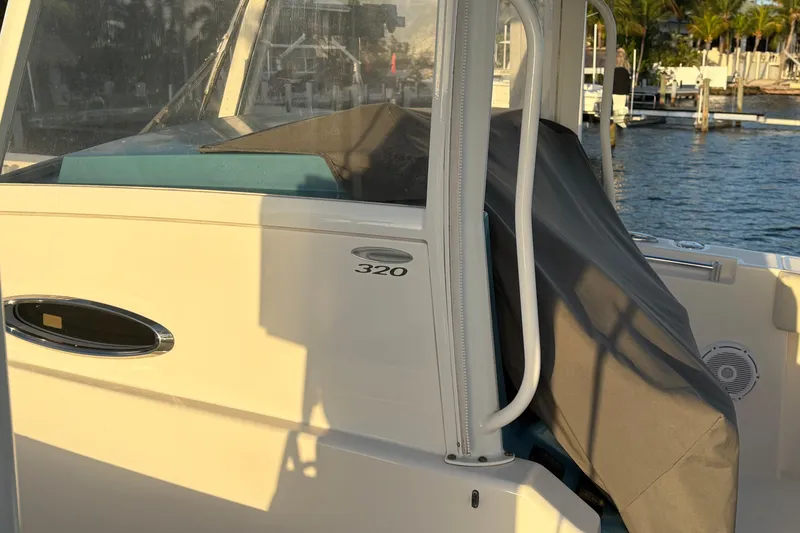 Slide: The Image of 2019 Cobia 320 Center Console boat docked by the water. - 23