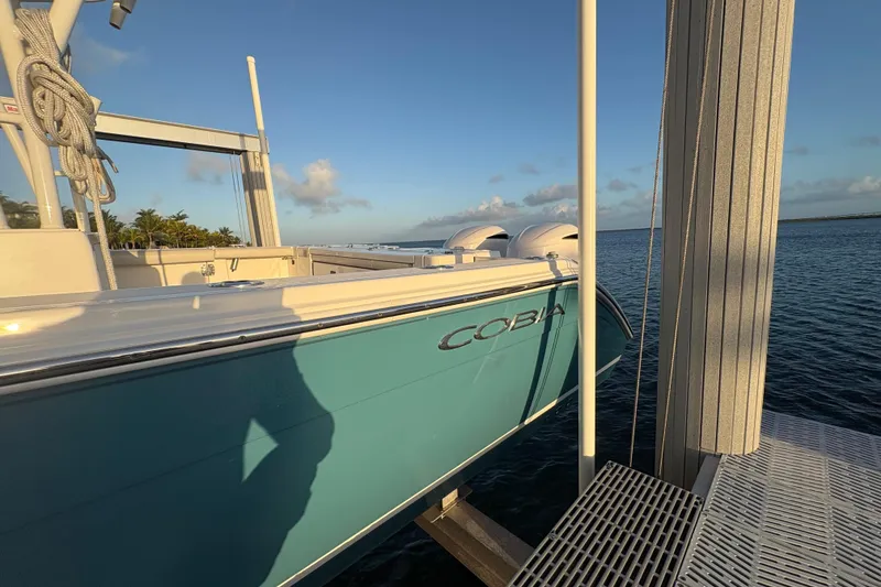 Slide: The Image of 2019 Cobia 320 Center Console boat docked by the ocean at sunset. - 3