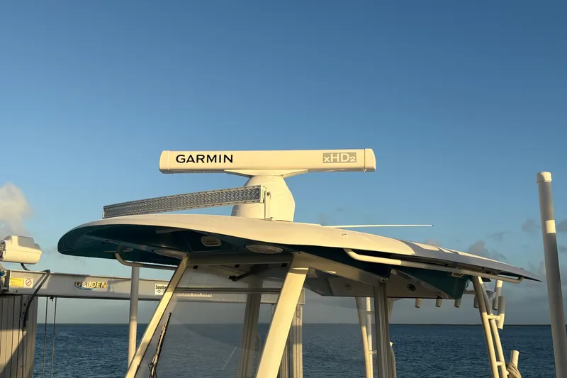 Slide: The Image of 2019 Cobia 320 Center Console with Garmin xHD2 radar, docked by the ocean. - 4