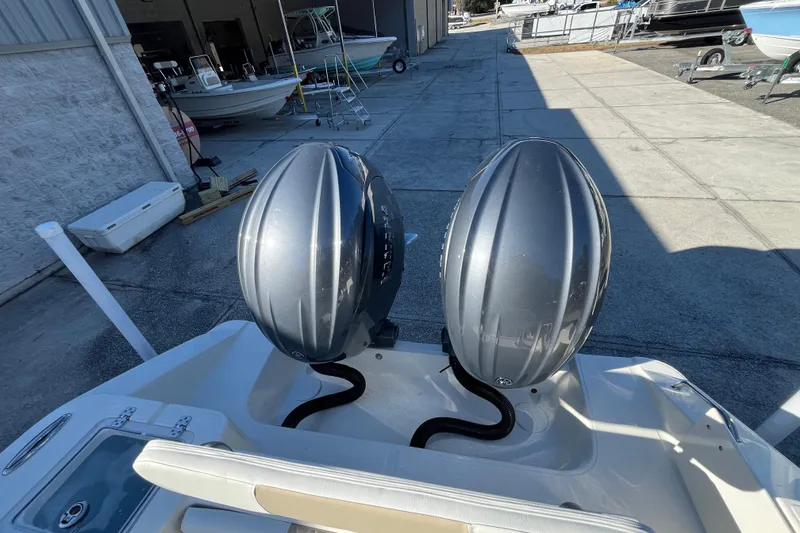 Slide: The Image of 2026 Bulls Bay 255 Center Console boat with dual outboard motors in a marina setting. - 24