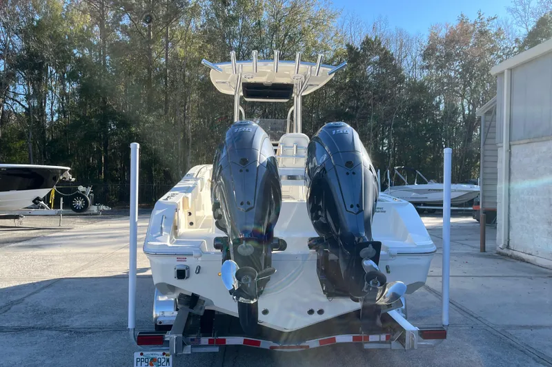 Slide: The Image of 2026 Bulls Bay 255 Center Console boat with dual outboard motors in a marina setting. - 6