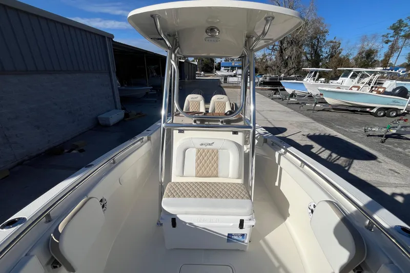 Slide: The Image of 2026 Bulls Bay 255 Center Console boat with seating and T-top in a marina setting. - 8