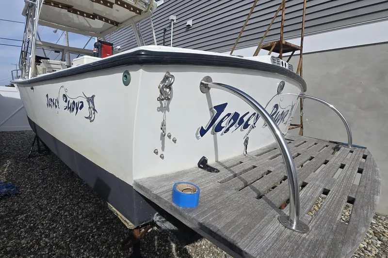Slide: The Image of 1992 Shamrock 260 Express boat on dry dock, featuring "Jersey Boyz" lettering on the stern. - 14