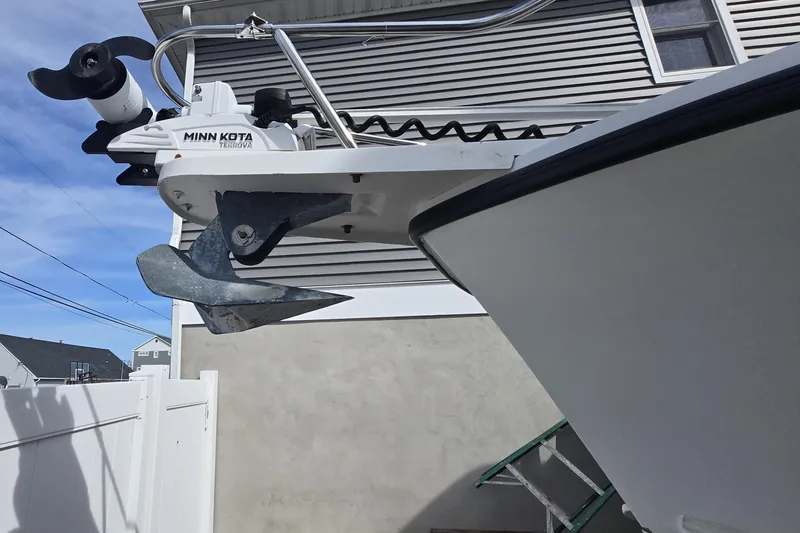 Slide: The Image of 1992 Shamrock 260 Express boat with Minn Kota trolling motor and anchor, docked near a house. - 15