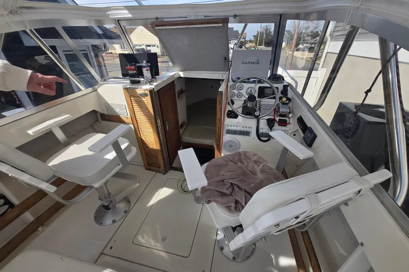 Slide: The Image of 1992 Shamrock 260 Express boat cockpit with steering wheel, seats, and navigation equipment. - 3