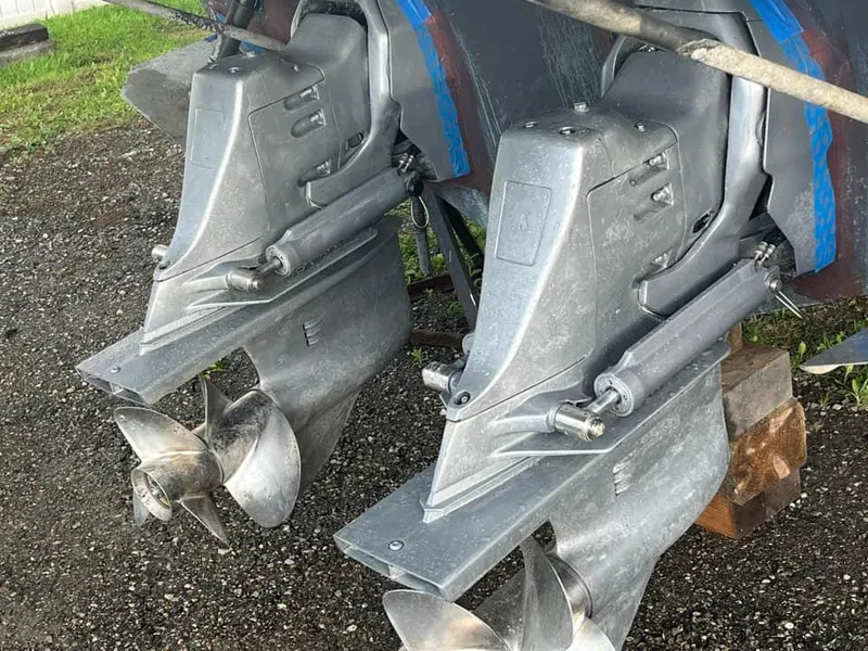 Slide: The Image of Twin outboard motors of a 2003 Regal Commodore 2860 boat on a gravel surface. - 18