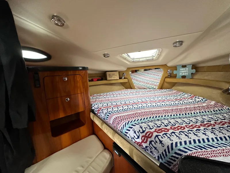 Slide: The Image of Cozy cabin interior of 2003 Regal Commodore 2860 with bed and wooden storage. - 24