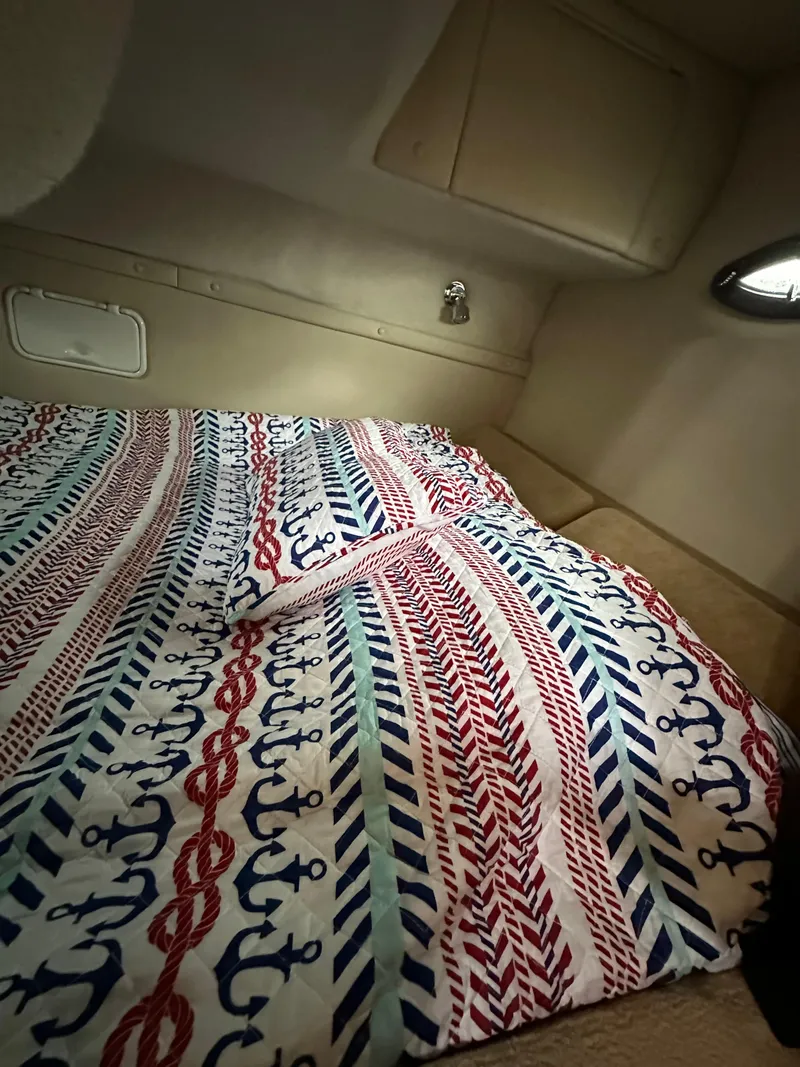 Slide: The Image of Interior cabin of a 2003 Regal Commodore 2860 with nautical-themed bedding. - 29