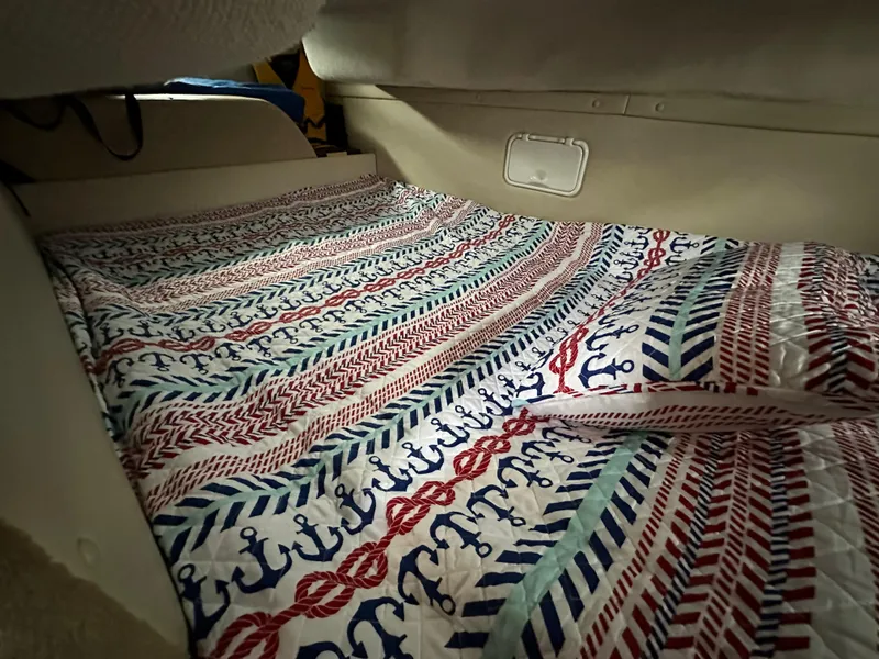 Slide: The Image of Cozy sleeping area in 2003 Regal Commodore 2860 with nautical-themed bedding. - 30