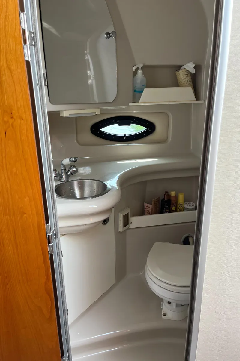 Slide: The Image of Compact bathroom in a 2003 Regal Commodore 2860 boat with sink, toilet, and storage shelves. - 31