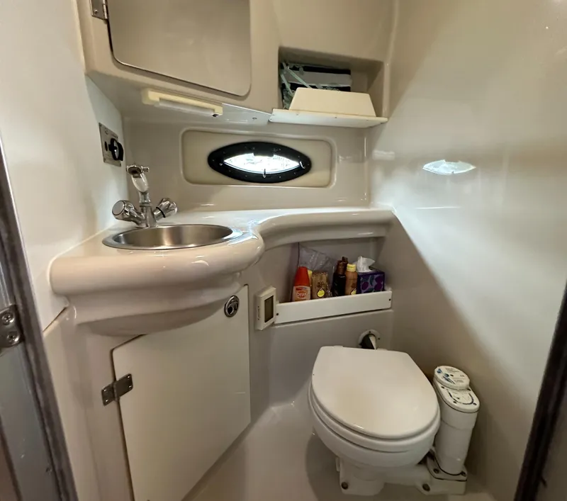 Slide: The Image of Compact bathroom in a 2003 Regal Commodore 2860 boat with sink, toilet, and storage. - 32