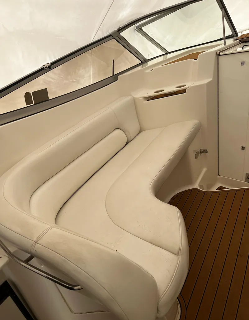Slide: The Image of 2003 Regal Commodore 2860 boat interior with white seating and wooden flooring. - 36