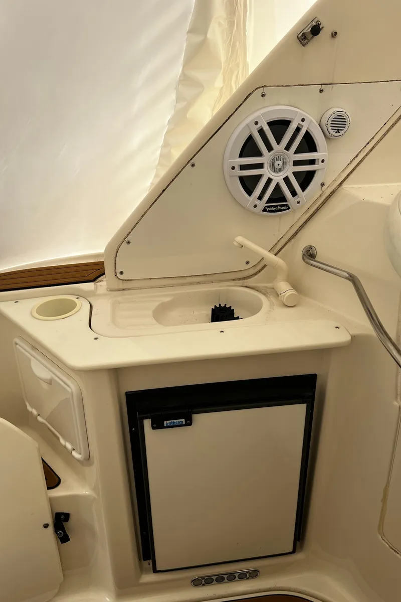 Slide: The Image of 2003 Regal Commodore 2860 boat interior with sink, mini fridge, and speaker. - 38