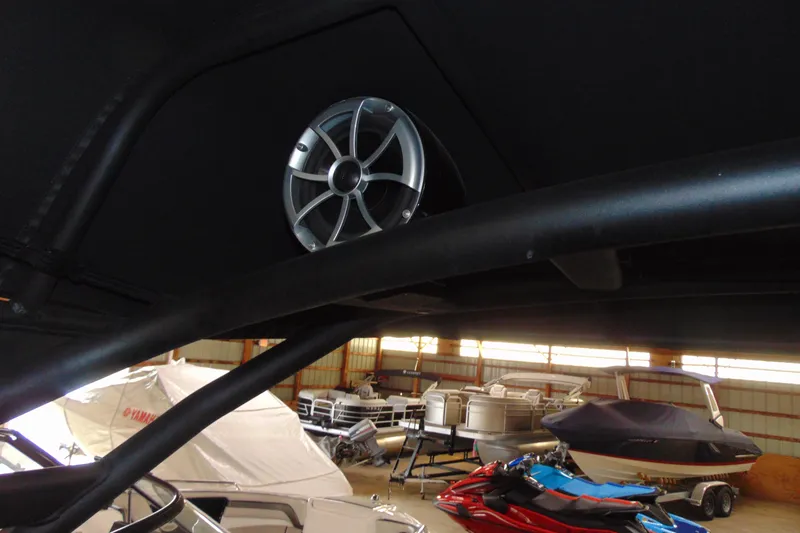 Slide: The Image of 2024 Yamaha Boats 255XD speaker system in a storage facility with covered boats. - 13