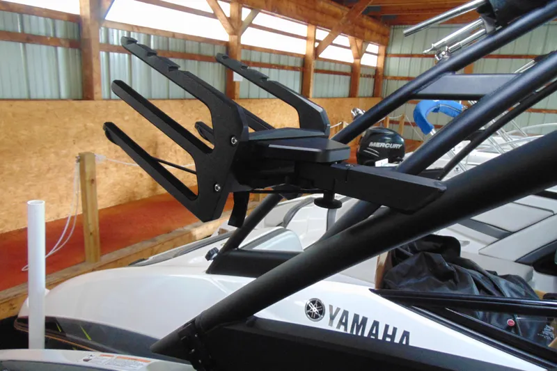 Slide: The Image of 2024 Yamaha Boats 255XD with wakeboard rack in a wooden boathouse. - 14