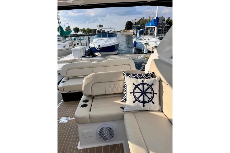 Slide: The Image of Luxurious 2018 Regal 35 Sport Coupe yacht interior with nautical-themed cushions in a marina setting. - 4